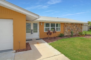 A residential house with a garage, a stone facade, and a well-maintained lawn. - Waterfront Paradise in Punta Gorda The Boat House (Punta Gorda)