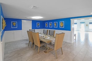 A dining area with a wooden table set for four, surrounded by chairs. - Waterfront Paradise in Punta Gorda The Boat House (Punta Gorda)