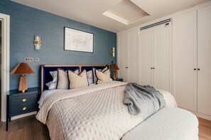Ein Schlafzimmer mit Bett, Nachttischen, einem Kleiderschrank und einer Wandkarte.
