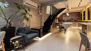 Een modern interieur met een trap, zithoek en een kaart aan de muur.