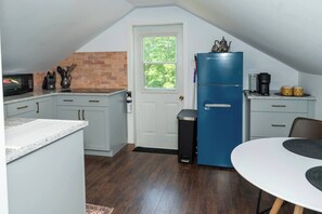 A compact kitchen with a refrigerator, microwave, and sink.