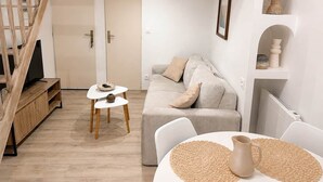 Een moderne woonkamer met een trap, een bank, een salontafel en een televisie.