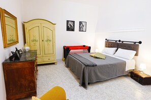 Ein Schlafzimmer mit einem Bett, einem Kleiderschrank, einem Schreibtisch und einem Stuhl.