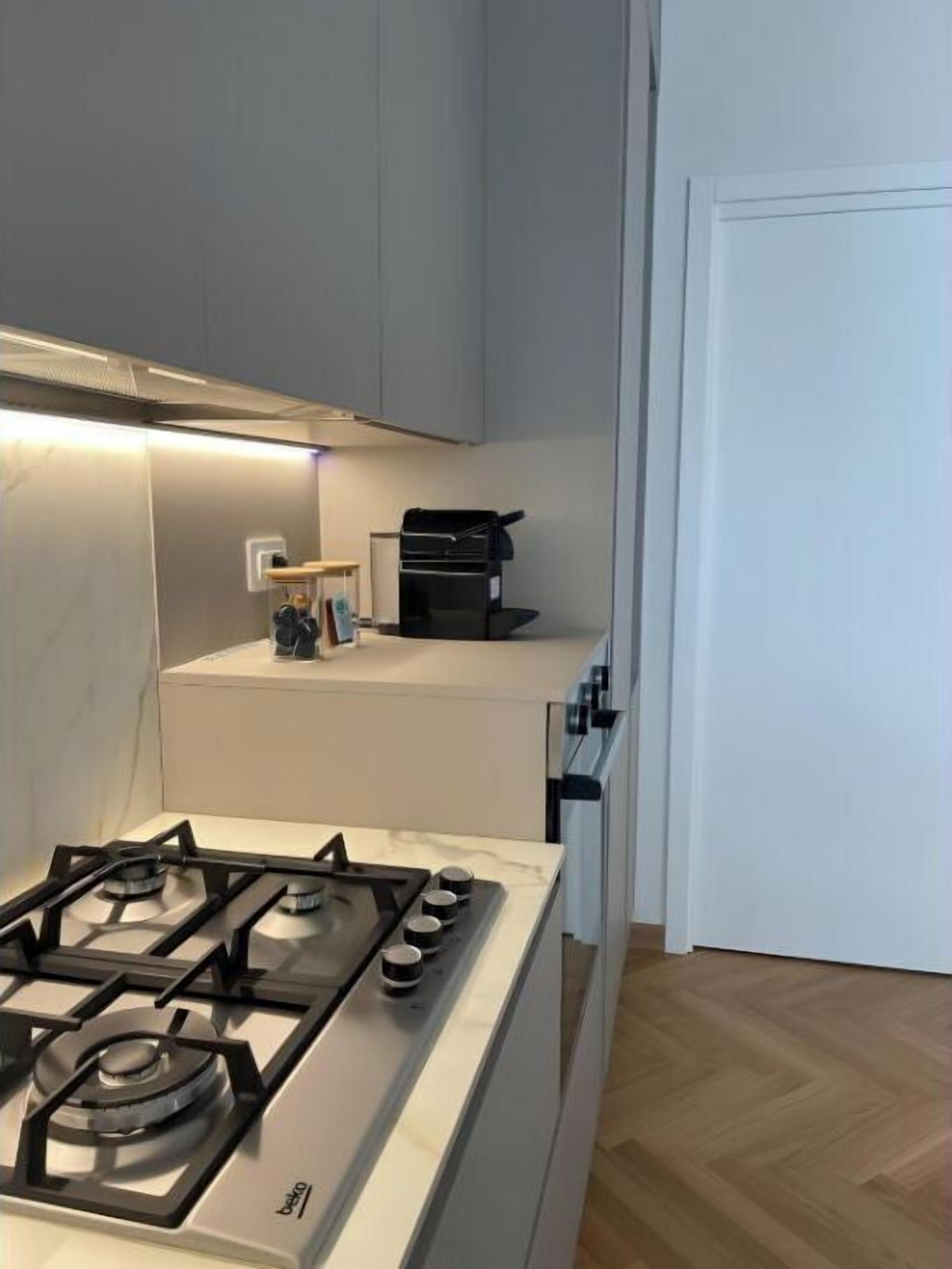 Een koffiezetapparaat/waterkoker, een koelkast, een oven, een kookplaat