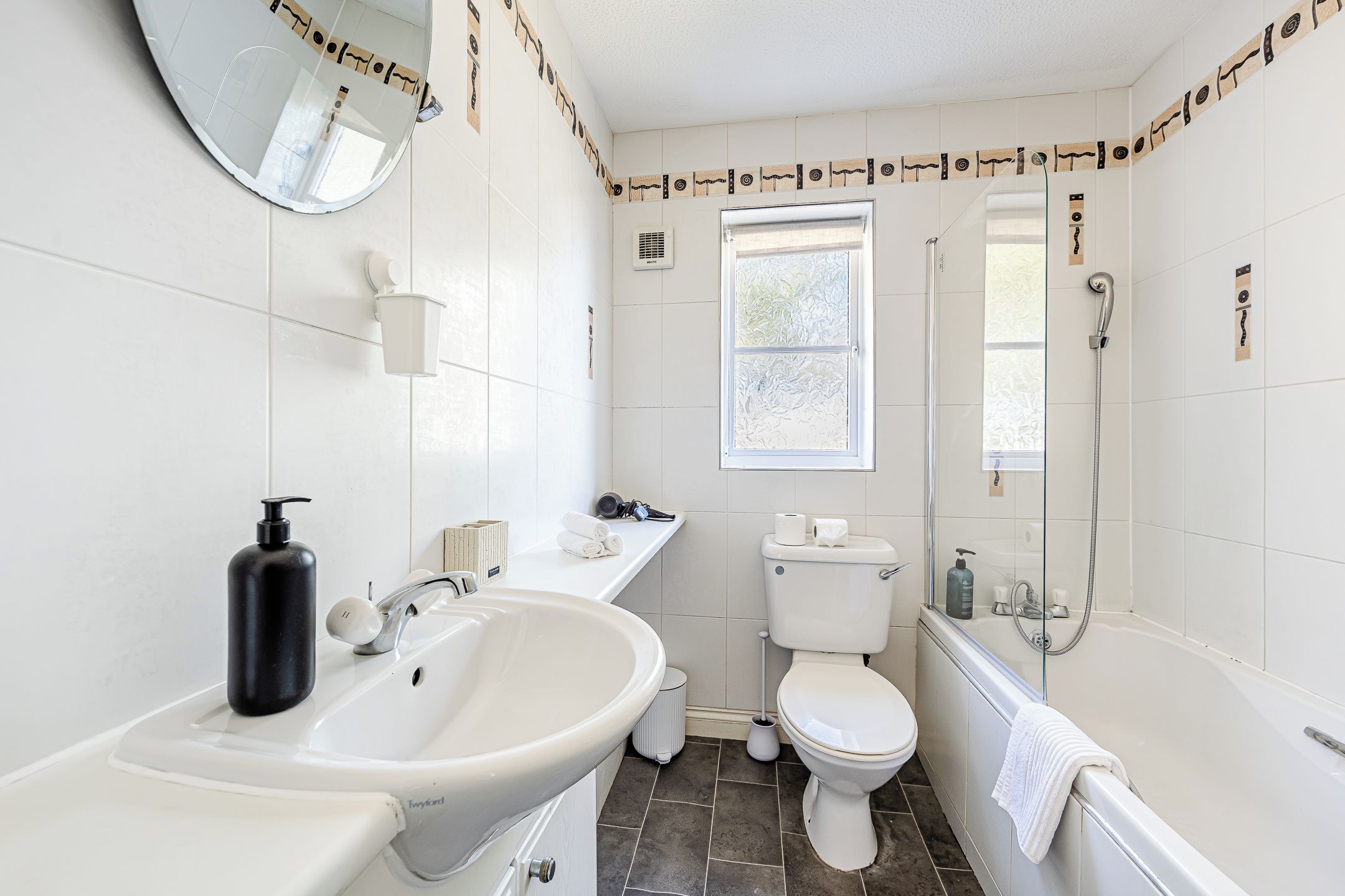 Une salle de bain avec un lavabo, des toilettes et une douche.