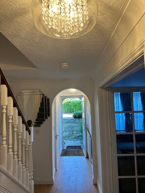 A hallway with a chandelier, a staircase, and a view of the outdoors. - Luxury 4 Bedroom Home, Sleeps 10, Garden, Free Parking, Hornchurch, Near London (Hornchurch)