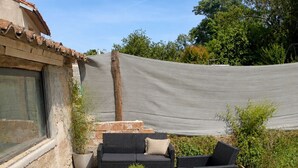 An outdoor patio with wicker furniture, a patterned rug, and a potted plant. - Charming house in the heart of the village with 3 private suites (Cintegabelle)
