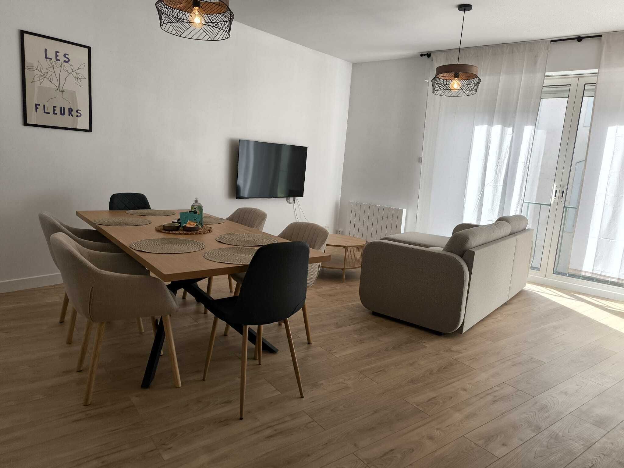Un espace repas moderne avec une table en bois, des chaises et un canapé.