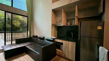 A modern kitchen with a built-in oven, a refrigerator, and wooden cabinets.