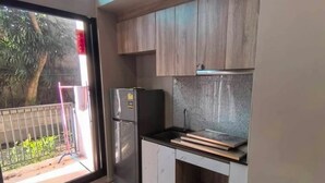 Eine moderne Küche mit Holzausstattung, einem Kühlschrank und einer schwarzen Arbeitsplatte.