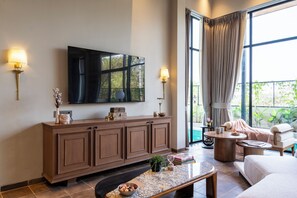Una sala de estar moderna con un televisor de pantalla plana grande, un mueble de madera y una zona de estar confortable con un sofá y un sillón.