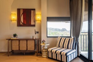 A room with a sofa, a cabinet, a small table with a vase, and a large window with a view. - Staymaster Timber Ridge - 4BR with Pool (Sangolda)