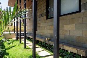 A modern building with a stone facade, a glass window, and a concrete bench. - Staymaster Timber Ridge - 4BR with Pool (Sangolda)