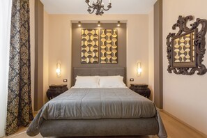 Une chambre à coucher avec un grand lit, deux tables de chevet, un panneau décoratif au mur et un miroir.