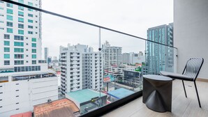 A balcony with a view of a cityscape, a chair, and a small table. - w Deluxe 2BR w Balcony View in San Francisco (Panama City)