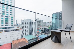 A balcony with a view of a cityscape, a chair, and a small table. - w Deluxe 2BR w Balcony View in San Francisco (Panama City)