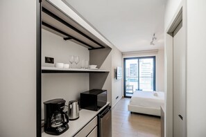 A modern hotel room with a kitchenette, a bed, and a large window. - w Upscale 2BR w Balcony AC in San Francisco (Panama City)