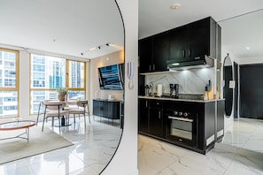 A modern kitchen with black cabinets, a built-in oven, and a large window. - w Polished 1BR Stay in Vibrant Obarrio (Panama City)