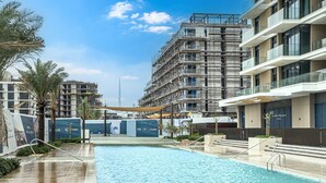 Ein Schwimmbecken mit Blick auf ein modernes Gebäude im Hintergrund.