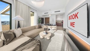 Ein modernes Wohnzimmer mit Sofa, Couchtisch und Essbereich.