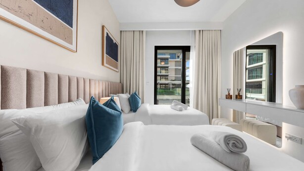 Ein Hotelzimmer mit zwei Betten, einem großen Fenster und Blick ins Freie.
