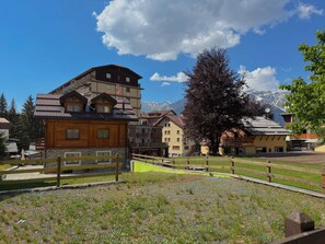 A wooden chalet with a balcony, a bar, and a view of snow-capped mountains. - The Clotes Hideaway - Steps From Chairlift (Sauze d'Oulx)