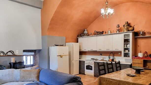 A compact living space with a kitchenette, a dining area, and a sofa. - Vathia Tower - Stone Mani Heaven Near the Beach (East Mani)