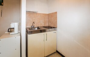 A small kitchenette with a coffee maker, a sink, and a stove. - 1 bedroom amazing home in CALCATOGGIO (CALCATOGGIO)