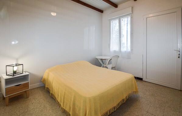 A room with a bed, a small table, a chair, and a wardrobe. - 1 bedroom amazing home in CALCATOGGIO (CALCATOGGIO)
