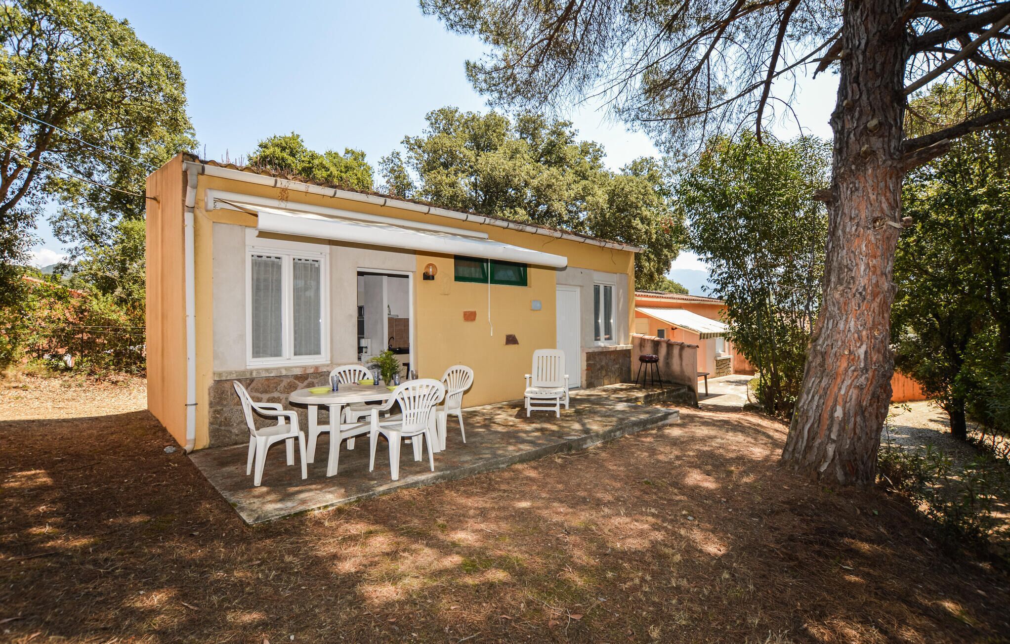 A single-story building with a patio area featuring a table and chairs.