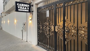 A gated entrance with a sign reading 'GARDEN VILLA 3 0501018662' and decorative metal gates. - Garden Villa 3 Ajman (Ajman)