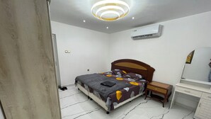 A bedroom with a bed, bedside table, and a mirror. - Garden Villa 3 Ajman (Ajman)