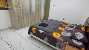 A bedroom with a bed, wardrobe, and a mirror. - Garden Villa 3 Ajman (Ajman)