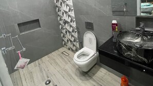 A modern bathroom with a toilet, sink, and shower. - Garden Villa 3 Ajman (Ajman)