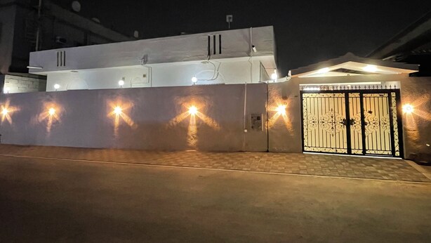 A gated property with a white exterior and a gated entrance. - Garden Villa 3 Ajman (Ajman)