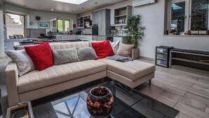 A modern living room with a sectional sofa, a glass coffee table, and a skylight. - The Annexe (Shipley)