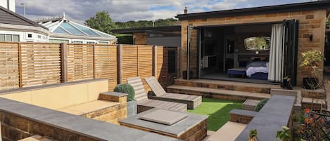 A backyard with a patio, seating area, and a covered outdoor space.