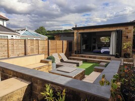 A backyard with a patio, seating area, and a covered outdoor space.