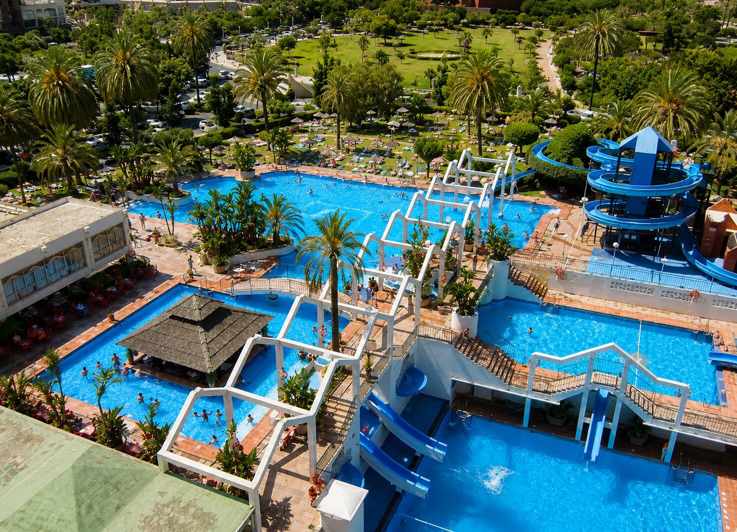 Un complexe hôtelier doté de plusieurs piscines, d’un toboggan aquatique et d’un paysage verdoyant luxuriant.
