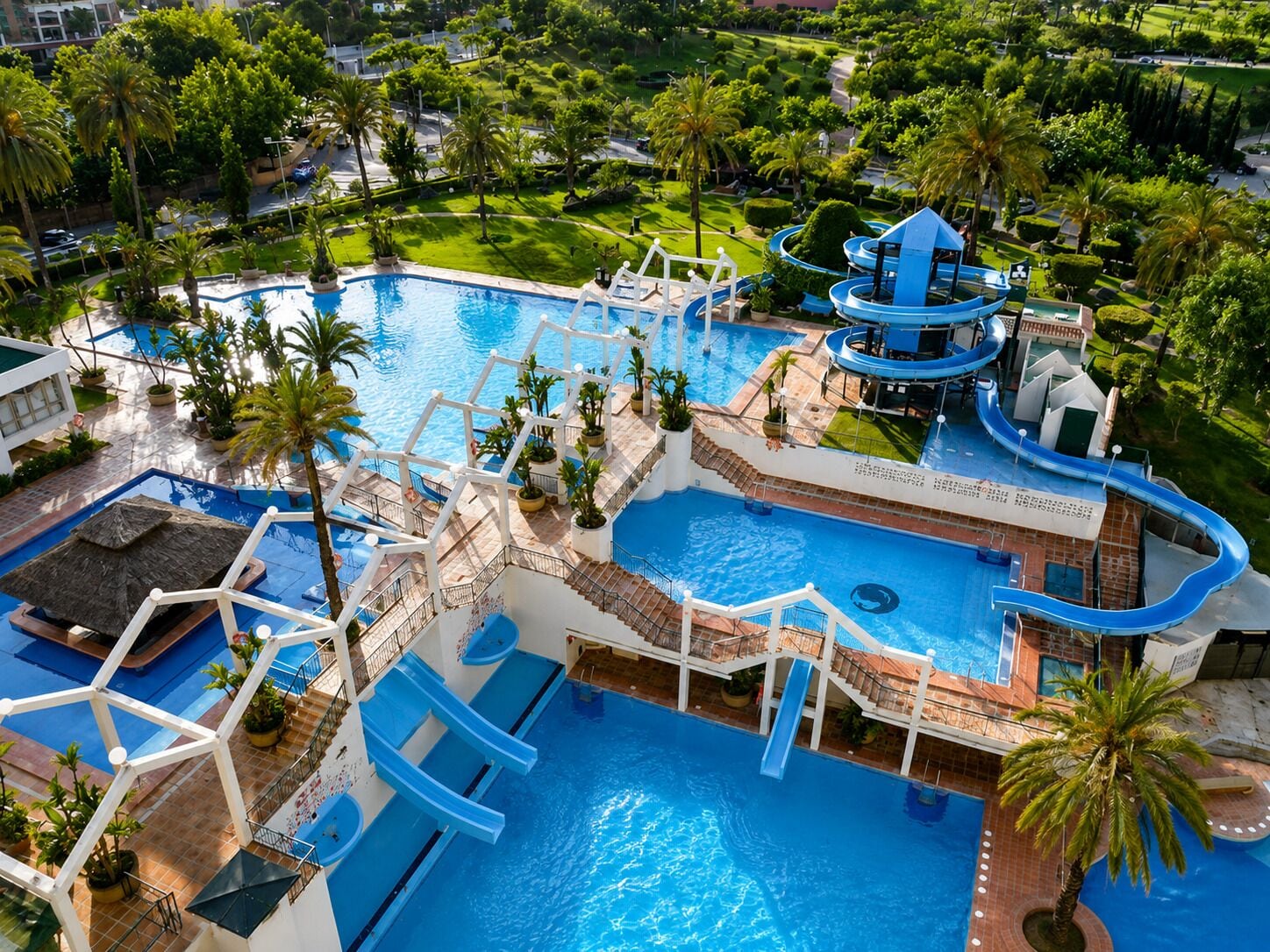A large outdoor swimming pool with multiple slides and a water park area.