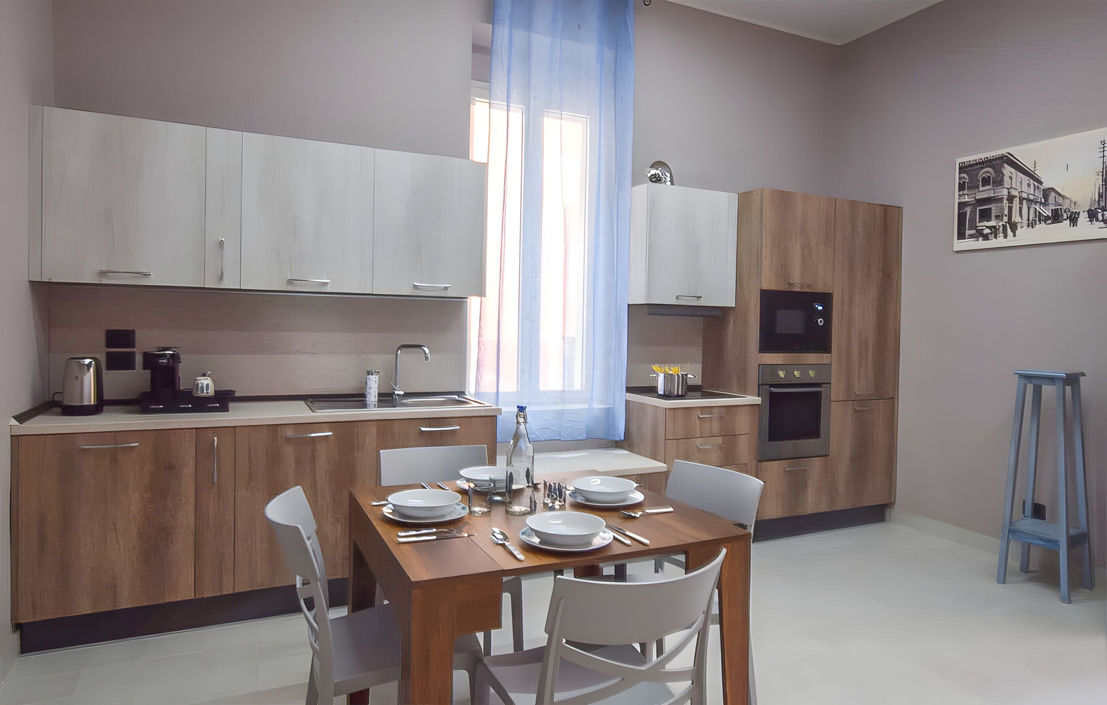 Una cucina moderna con mobili in legno, un tavolo da pranzo per quattro persone e una tenda blu.