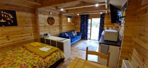 A wooden cabin room with a bed, a sofa, a desk, and a television. - Badger Lodge dog Friendly nr Anderby Creek (Alford)