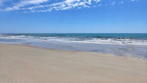 Ein Strand mit blauem Himmel und ruhiger See.