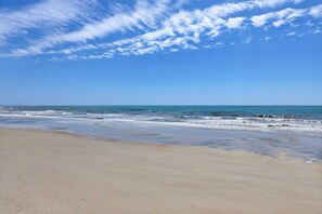 Ein Strand mit blauem Himmel und ruhiger See.