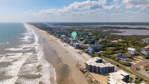 An aerial view of a coastal area with a beach, residential buildings, and a water body. - On Porpoise #223 | Luxury Oceanfront Escape in North Topsail Beach (North Topsail Beach)