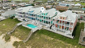 A multi-story beachfront hotel with balconies, a swimming pool, and a view of the surrounding area. - Beach Walk #225-Oceanfront Duplex in Surf City, Pool, Elevator, Dog Friendly! (Surf City)