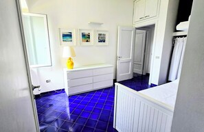 A bathroom with a white vanity, a yellow lamp, and a blue-tiled floor. - VILLA ANNA IN CASTELLABATE (San Marco)
