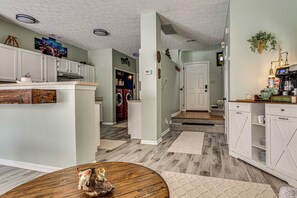 A kitchen with white cabinets, a wooden island, and a dining area with a round table. - 1 Mi to Eagle Creek Res: Family-friendly Indy Home (Indianapolis)