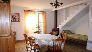 Quarto com mesa de jantar, cadeiras, cama, escada e um lustre.