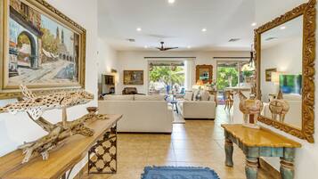 A spacious living room with a sofa, a coffee table, and a large mirror.